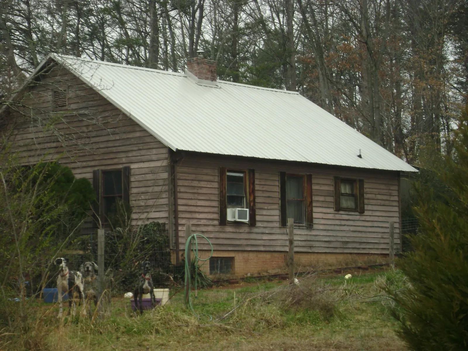 White metal roof on an old wood sided farmhouse, from a Metal Roof Installation job in Lynnville